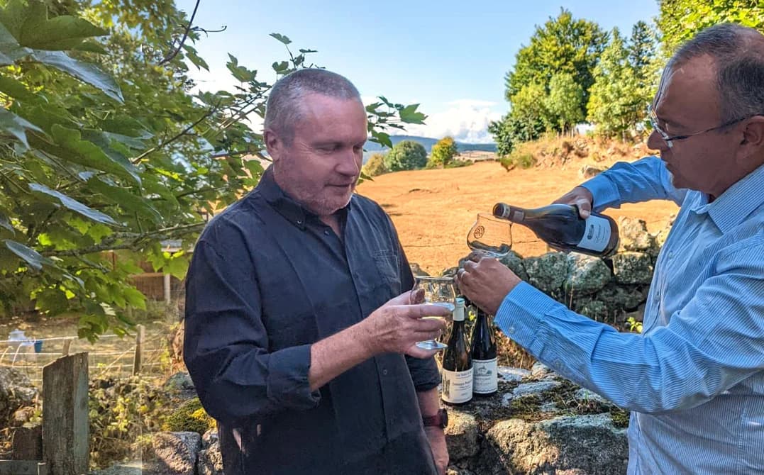 Patrick et Jean-Louis partagent un verre de vin au milieu des vignes